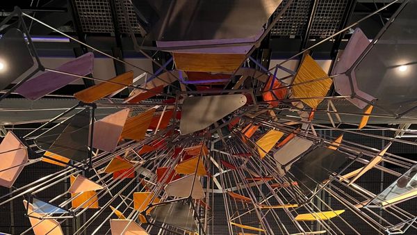 A huge mosaic of panels and mirrors at the ceiling of the third floor of the Science Museum in London.