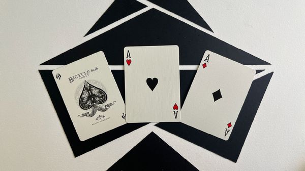 A black ace of spades, ace of hearts, and ace of diamonds.