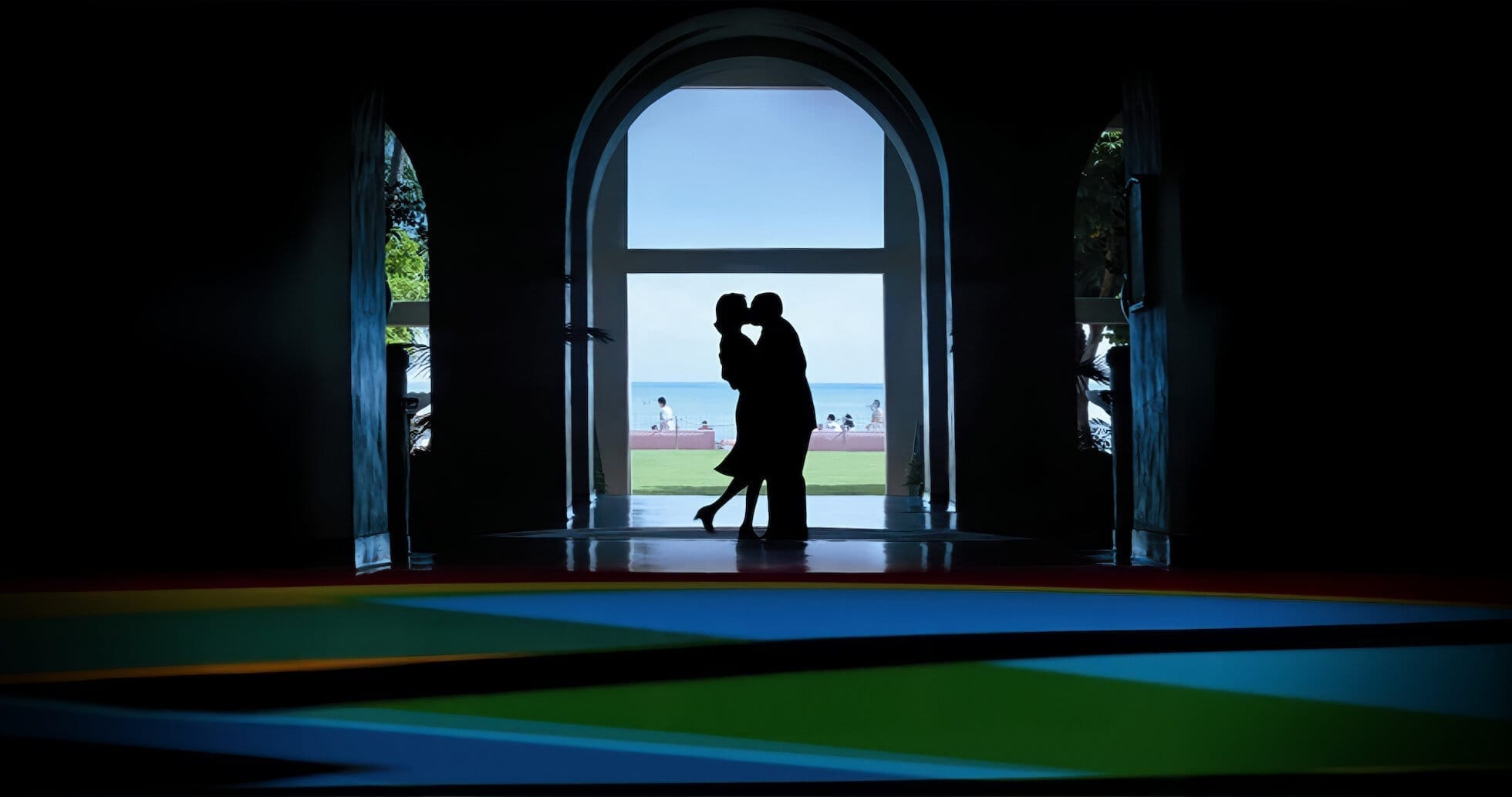 The silhouette of Emily Watson and Adam Sandler kissing with the sunny Hawaii in the background.