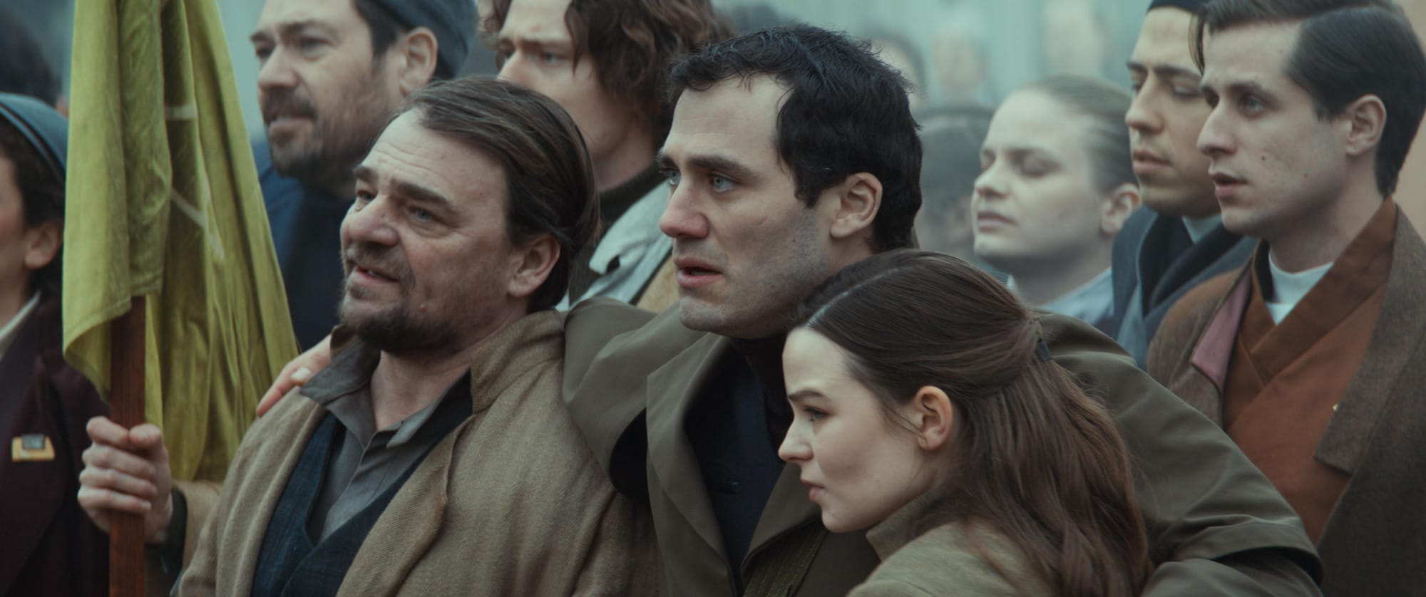 A group of people of various backgrounds and ages stand together and sing