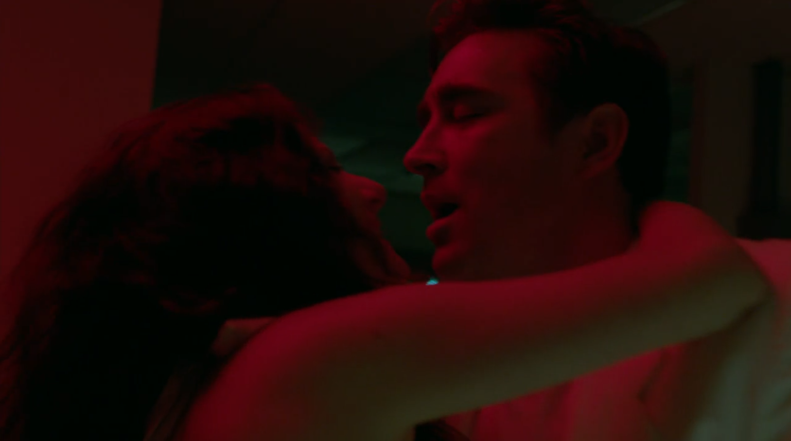 A man and woman make love under the light of the exit light in a mainframe room.