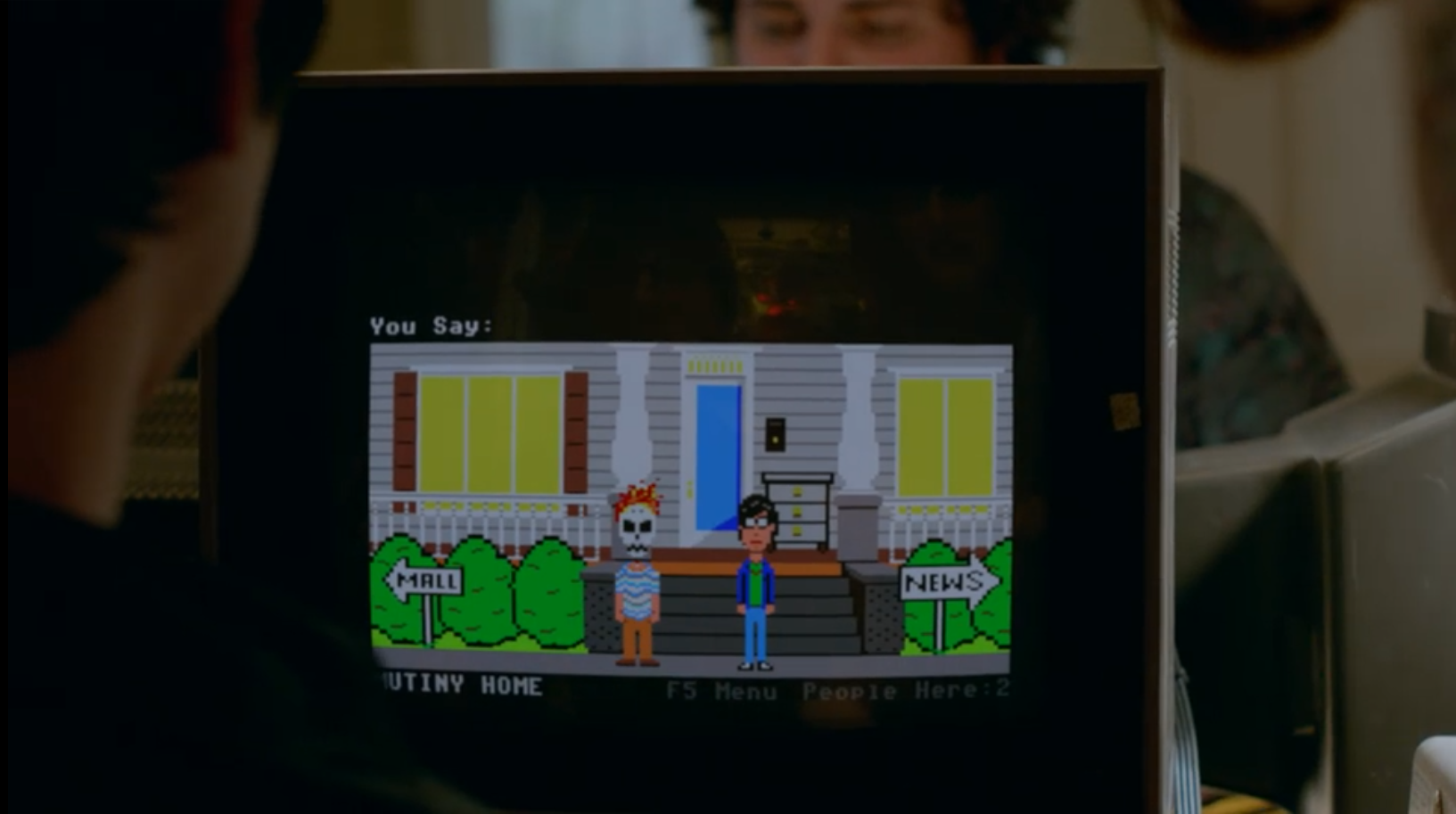 A computer screen showing two avatars, one looking like a normal person and the other with a skull mask with fire for hair, standing in front of a  house.