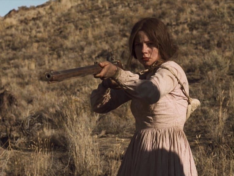 Emily Tetherow (Michelle Williams) has a determined look on her face as she aims her rifle in Meek's Cutoff
