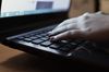 Someone typing on a laptop