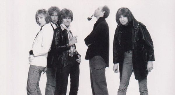 Black-and-white full-length portrait of British Lions circa 1978—Dale Griffin, John Fiddler, Ray Majors, Morgan Fisher, and Overend Watts lined up against a white backdrop.