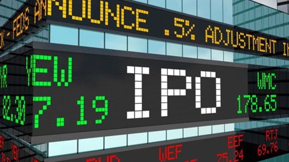 Un tableau d'affichage boursier affiche le mot IPO en blanc, entouré d'autres informations boursières en vert et jaune.
