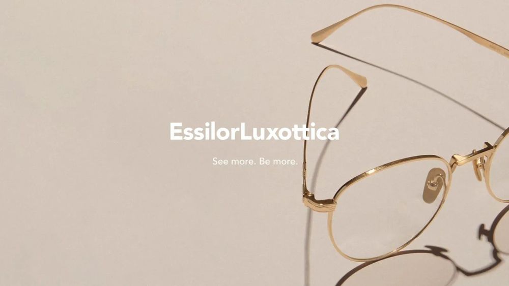 Lunettes dorées EssilorLuxottica sur fond beige, symbolisant la vision et l'optique.