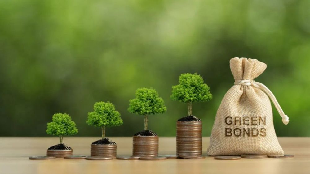 Arbres poussant sur des piles de pièces de monnaie, à côté d'un sac en toile de jute étiqueté 'Green Bonds'.