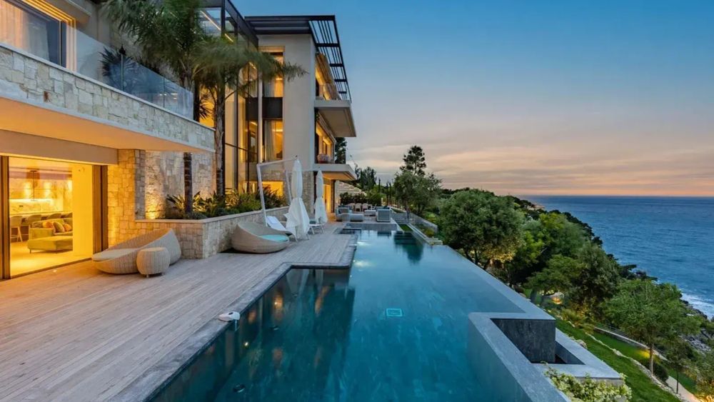 Maison de luxe avec piscine à débordement et vue sur la mer, illustrant l'immobilier de luxe et l'impact de la taxe d'habitation.