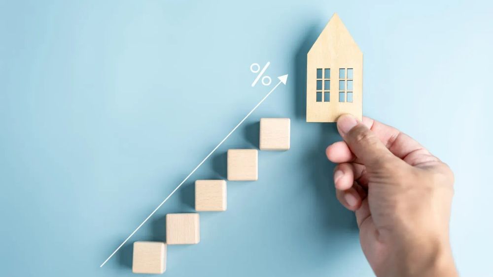 Illustration de la croissance du marché immobilier avec des blocs en bois et une maison miniature.