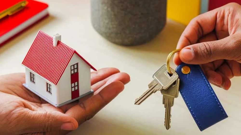 Une main tenant une maquette de maison et une autre main offrant des clés, symbolisant l'acquisition immobilière.