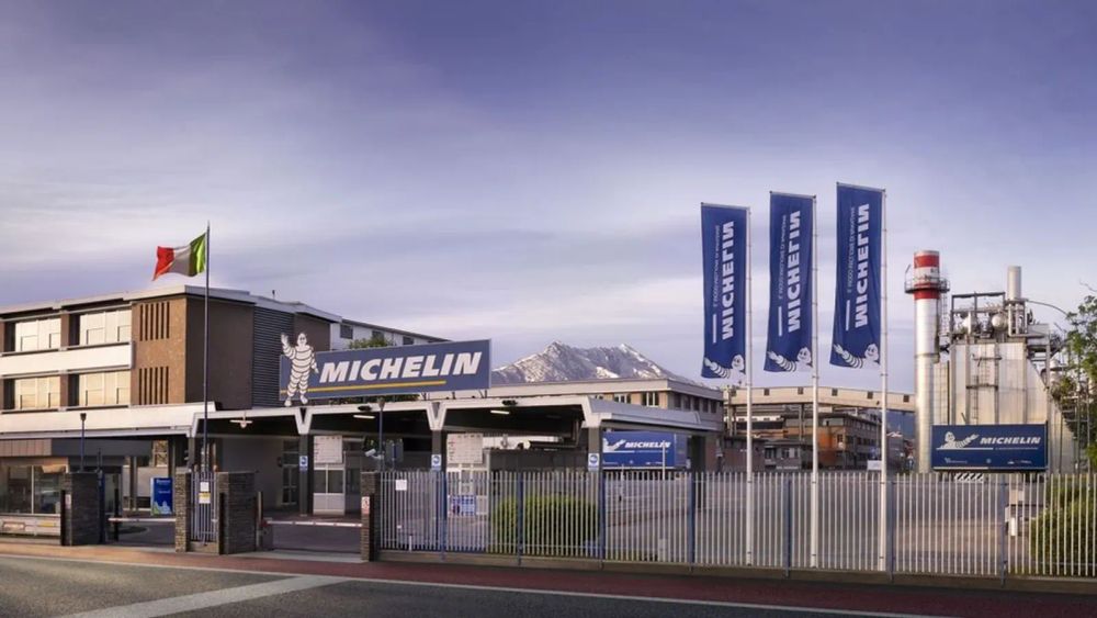 Usine Michelin avec le drapeau italien et des bannières Michelin flottant au vent.