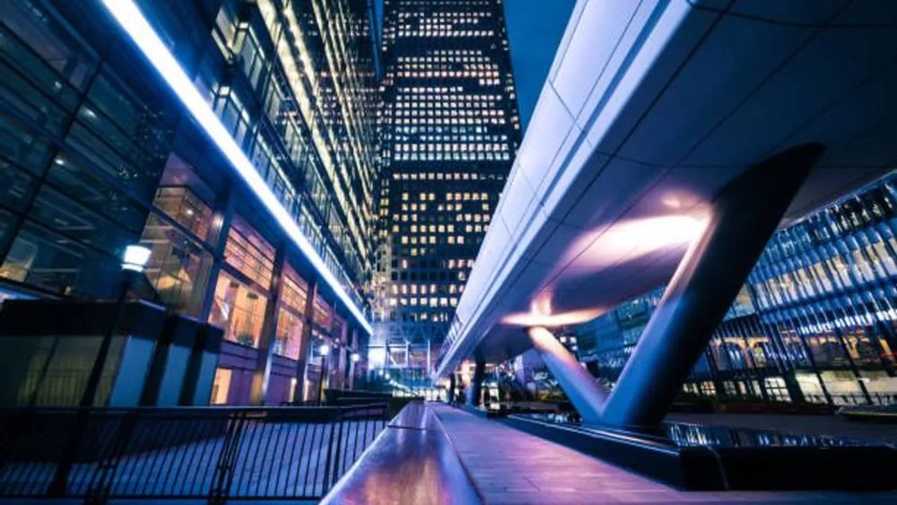 Vue nocturne de Canary Wharf, Londres, illustrant l'architecture moderne et l'innovation financière, symbolisant la tokenisation immobilière en Europe.