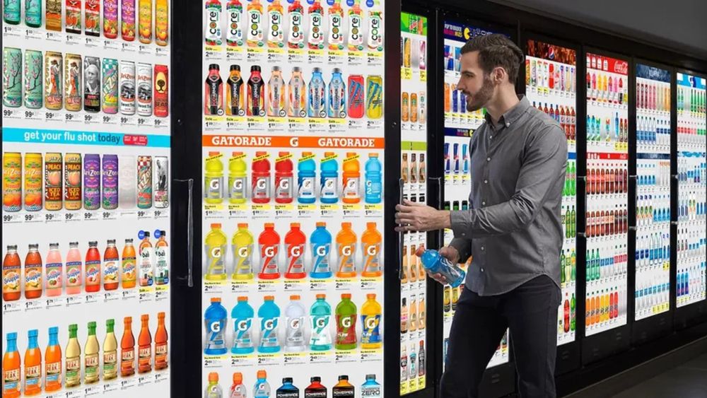 Un homme choisit une boisson dans un rayon de supermarché, illustrant l'environnement du retail media.