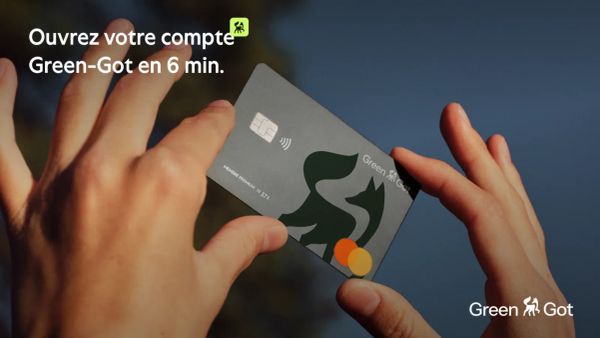 Carte bancaire Green-Got tenue à la main, mettant en avant le logo avec le renard et l'écureuil.