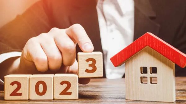 Image symbolisant l'année 2023 et l'immobilier, avec des cubes en bois formant le nombre et une petite maison.