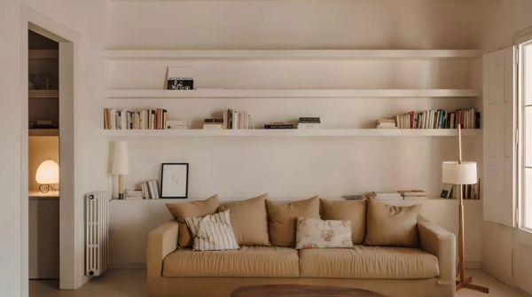 Salon lumineux et épuré avec canapé beige, étagères intégrées et décoration minimaliste, évoquant un intérieur Harmony Homes.