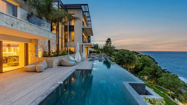 Maison de luxe avec piscine à débordement et vue sur la mer, illustrant l'immobilier de luxe et l'impact de la taxe d'habitation.