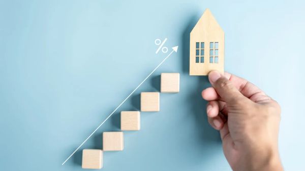 Illustration de la croissance du marché immobilier avec des blocs en bois et une maison miniature.