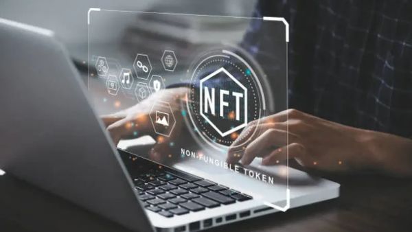 Un homme travaille sur un ordinateur portable avec un overlay NFT, symbolisant l'utilisation des NFTs en entreprise.