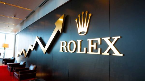 Logo Rolex doré sur un mur sombre, accompagné d'un graphique boursier ascendant, symbolisant la croissance et le succès de la marque.