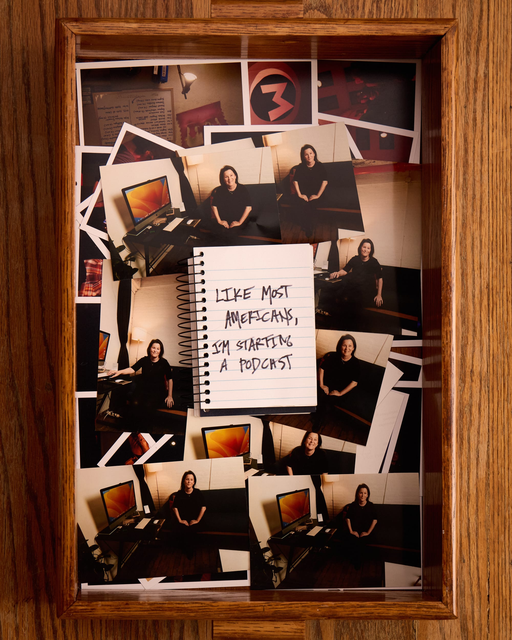We see a tray of 4x6 photos. In them, Mindy looks friendly and like she's sitting for a photo on the couch in her studio. There's a notebook that says "Like most Americans, I'm starting a podcast."