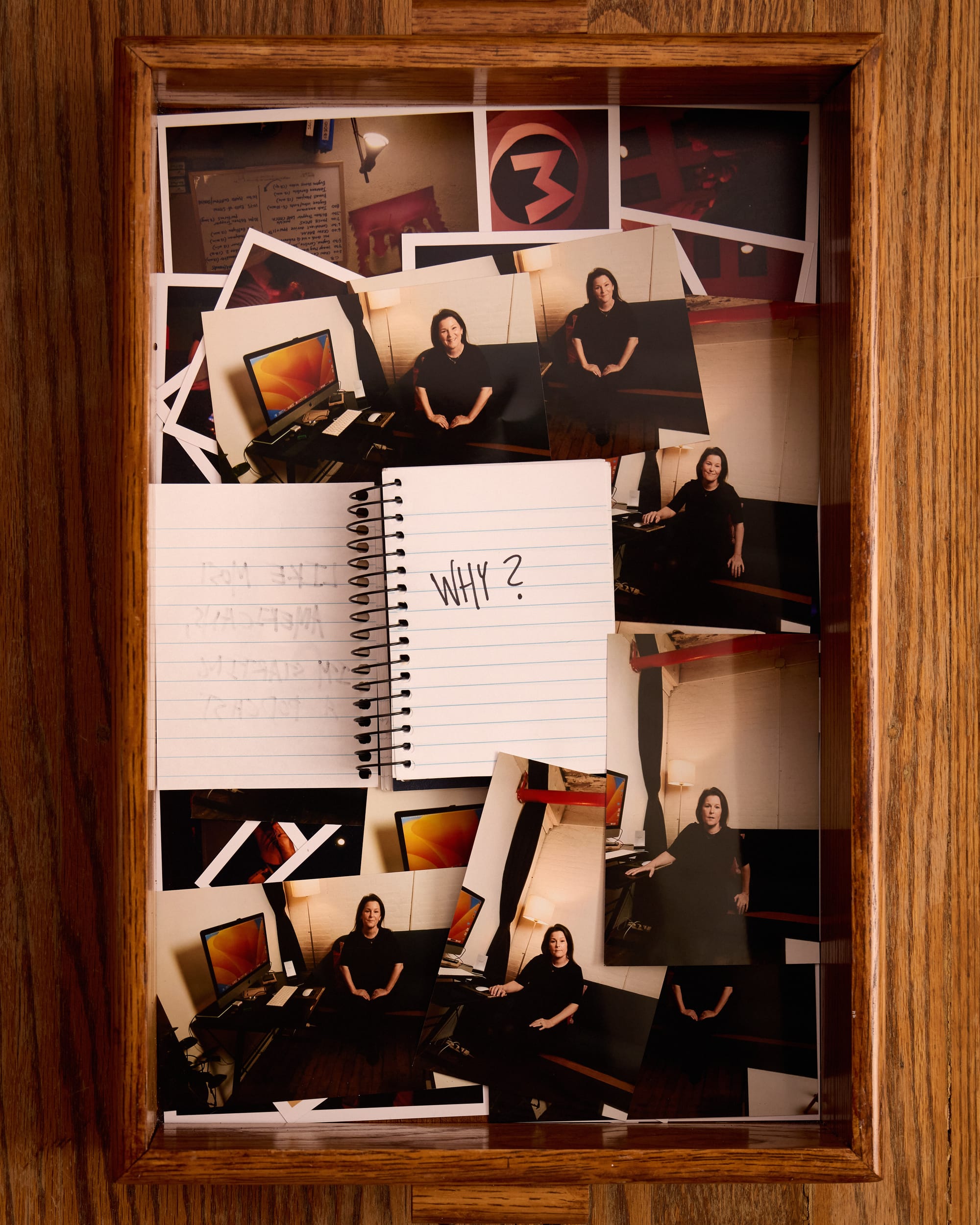 The notebook now says “Why?”. We see a tray of 4x6 photos. In them, Mindy looks friendly and like she's sitting for a photo on the couch in her studio. 