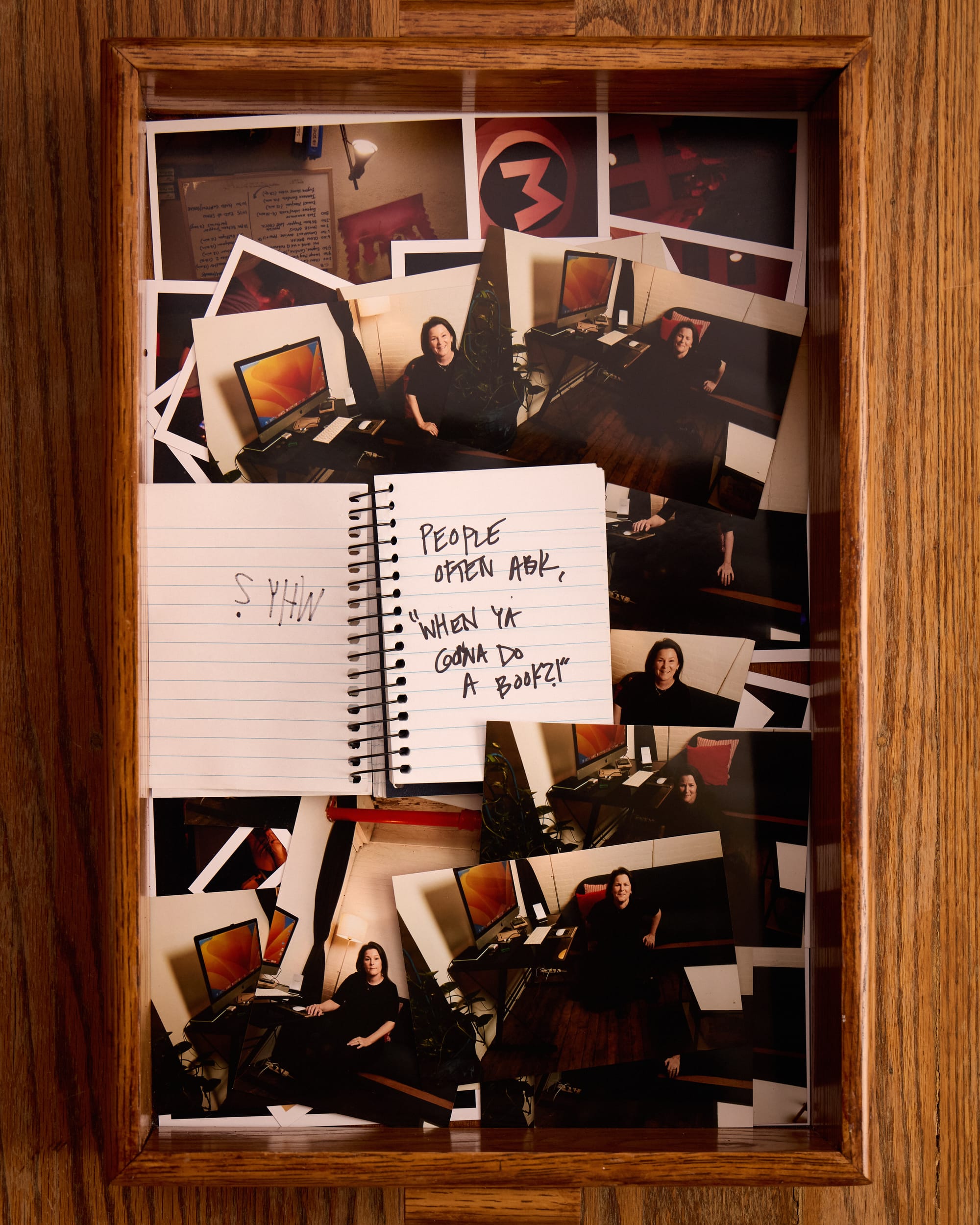 The notebook now says “People often ask me, "When ya gonna do a book?!"”. In the tray of 4x6 photo, Mindy looks stressed while sitting on the couch in her studio. 