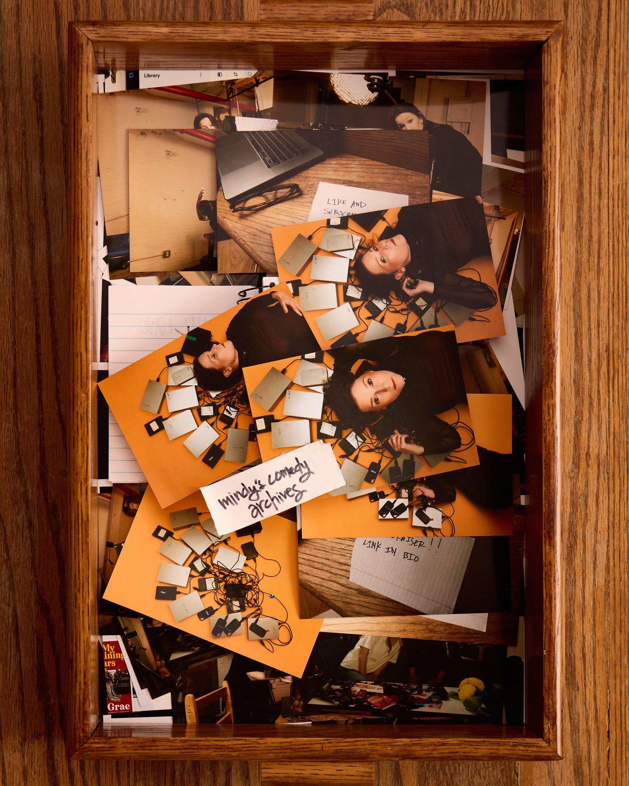 Notebook has now been covered in promo photos of Mindy Tucker surrounded by hard drives. There’s a piece of gaffer tape that says “Mindy's Comedy Archives”. 