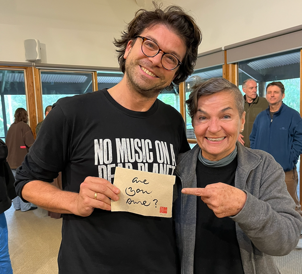 Me grinning at the camera, next to Christiana Figueres, grinning and pointing at the small piece of paper I am holding, with calligraphy saying "are you sure?"
