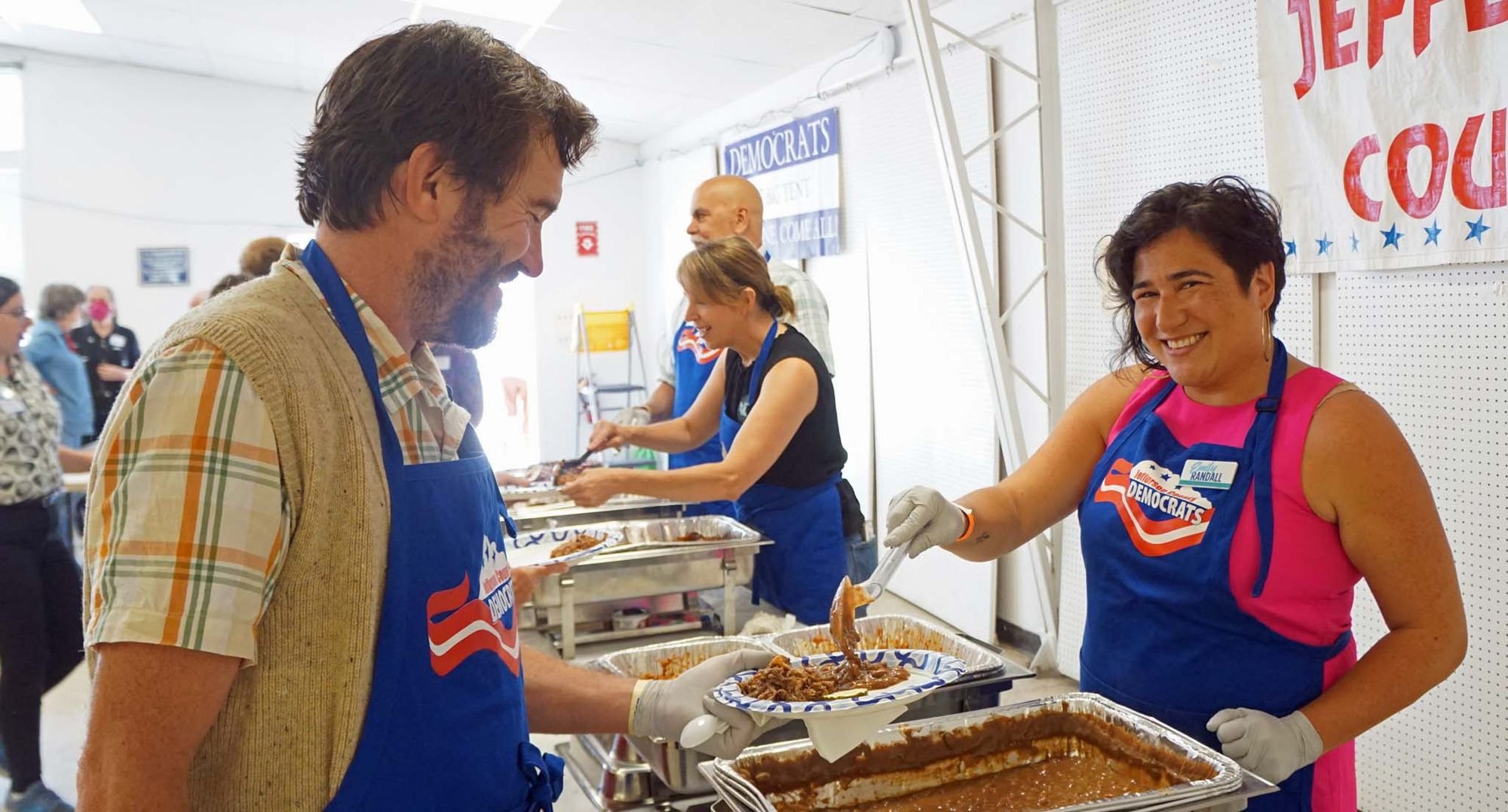   Congressional candidate Emily Randall serves Jefferson County Commissioner Greg Brotherton some beans. Her opponent, Hilary Franz, is in the background, along with Jefferson County Sheriff Joe Nole.   