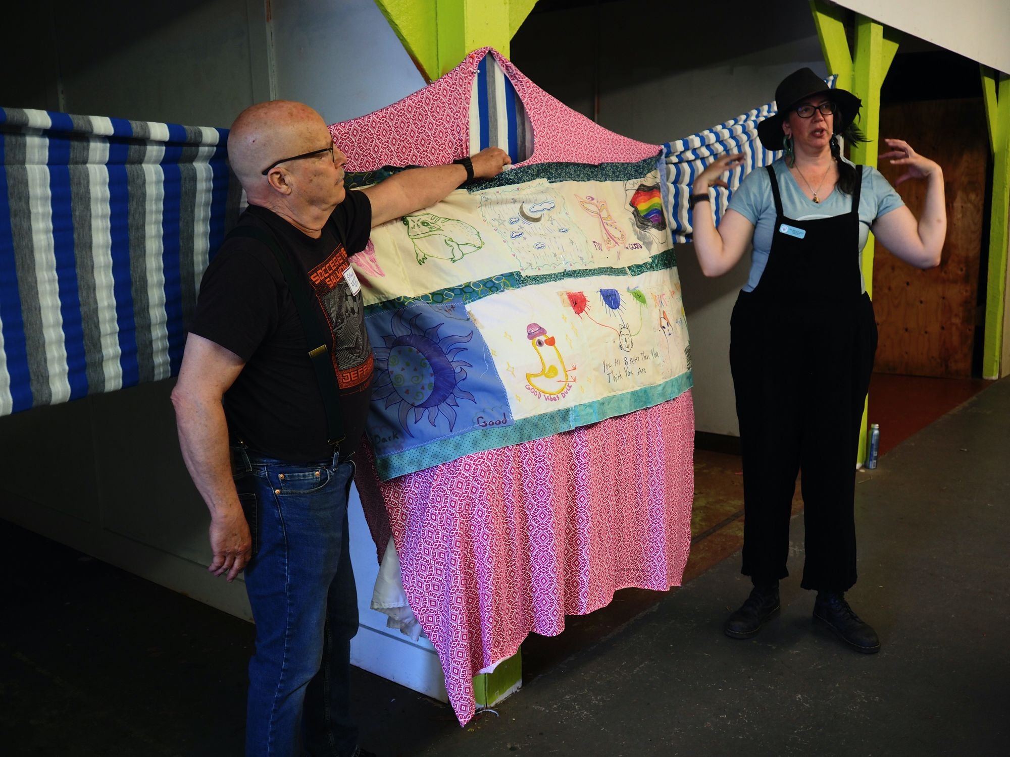   Benji Project staff members Steve Baird and Rose Martin try out a hoop skirt under the cozy sweater to fatten the cat belly. Beacon photo by Derek Firenze  