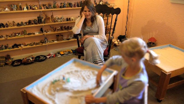   At Jumping Mouse Children’s Center, former therapist Jean Scarboro spends time with a youngster. Photo by Scott France  