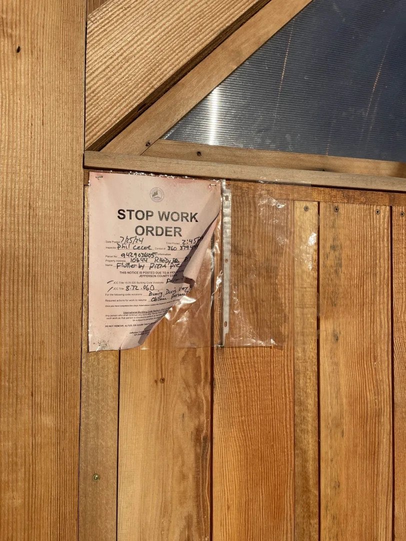   A faded stop work order on Flutter By’s door. Photo by Angela Downs.  