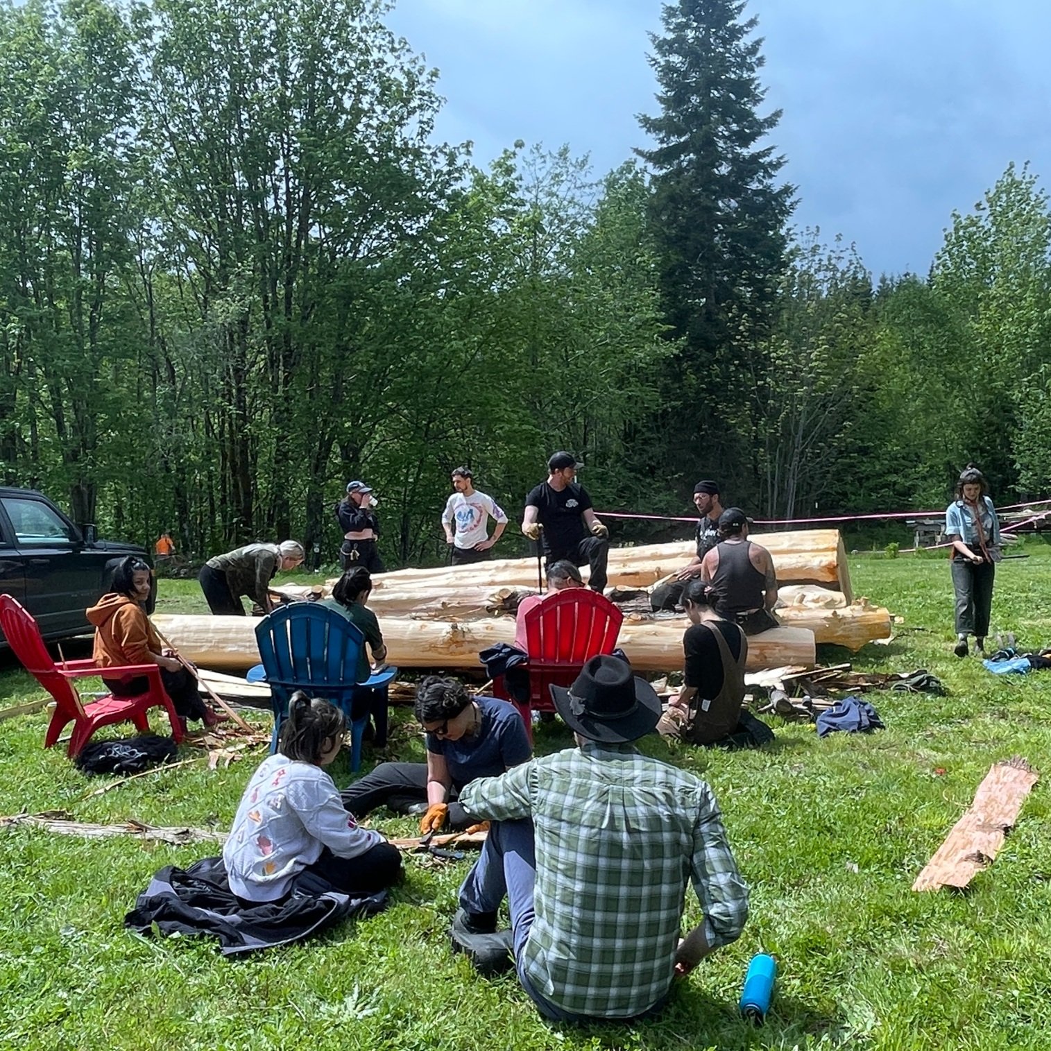   Volunteers strip bark from cedar logs that will become part of the Longhouse For the People. Photo by Angela Downs.  