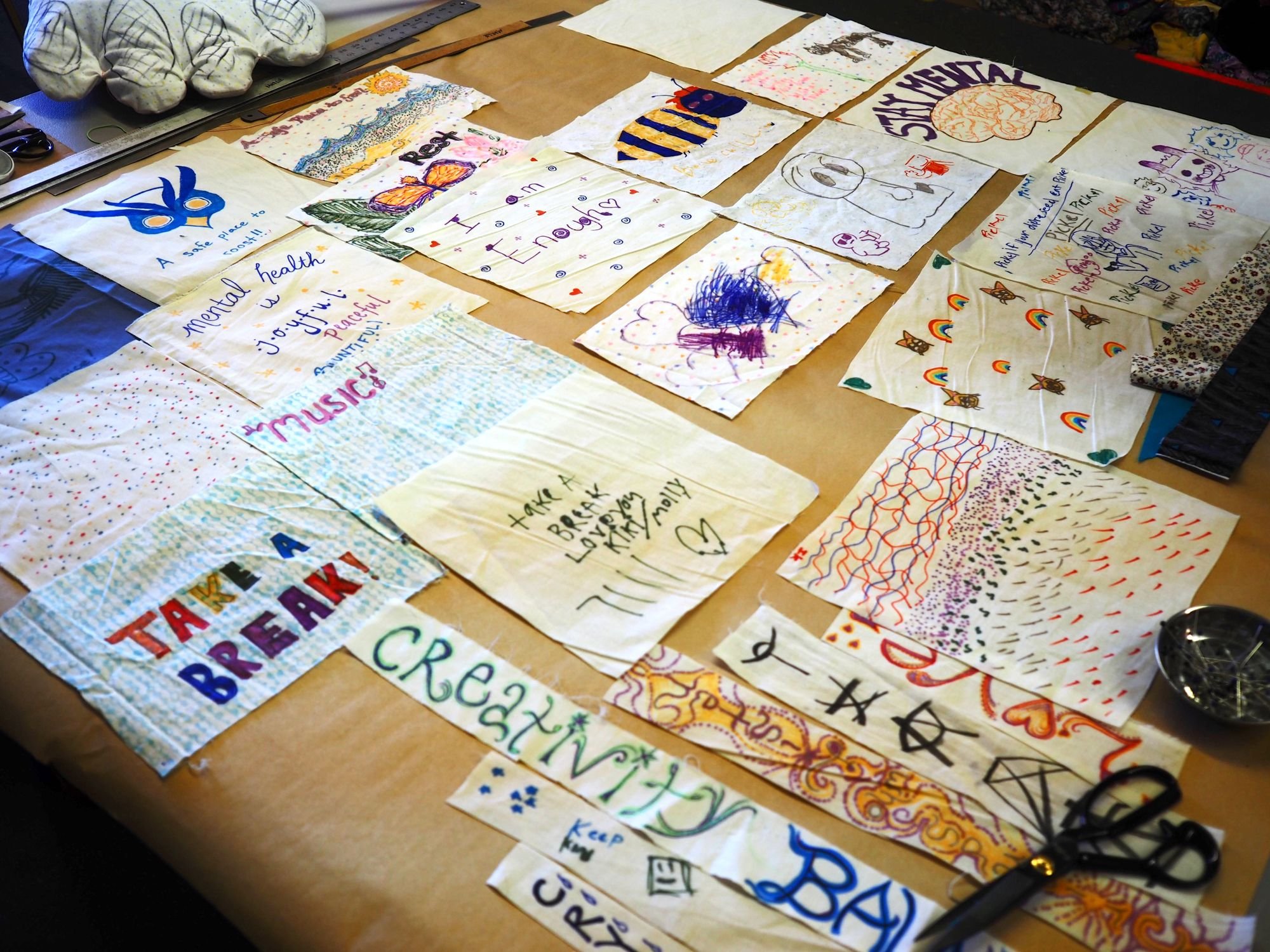   Caring messages on patches decorated by local youth wait to be added to the sweater. Beacon photo by Derek Firenze  