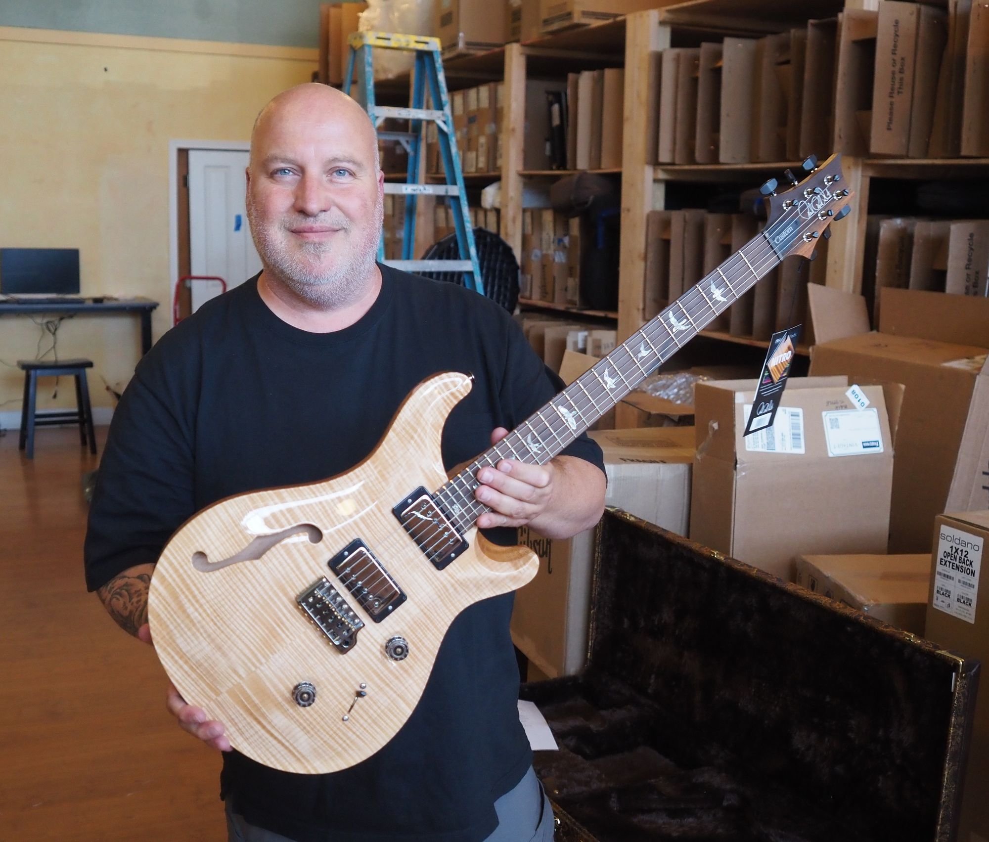   James Schultz, owner of Quimper Sound, holds a Paul Reed Smith custom 24 semi hollow guitar that just arrived at the shop made from woods he picked out in 2021. Beacon photo by Derek Firenze  