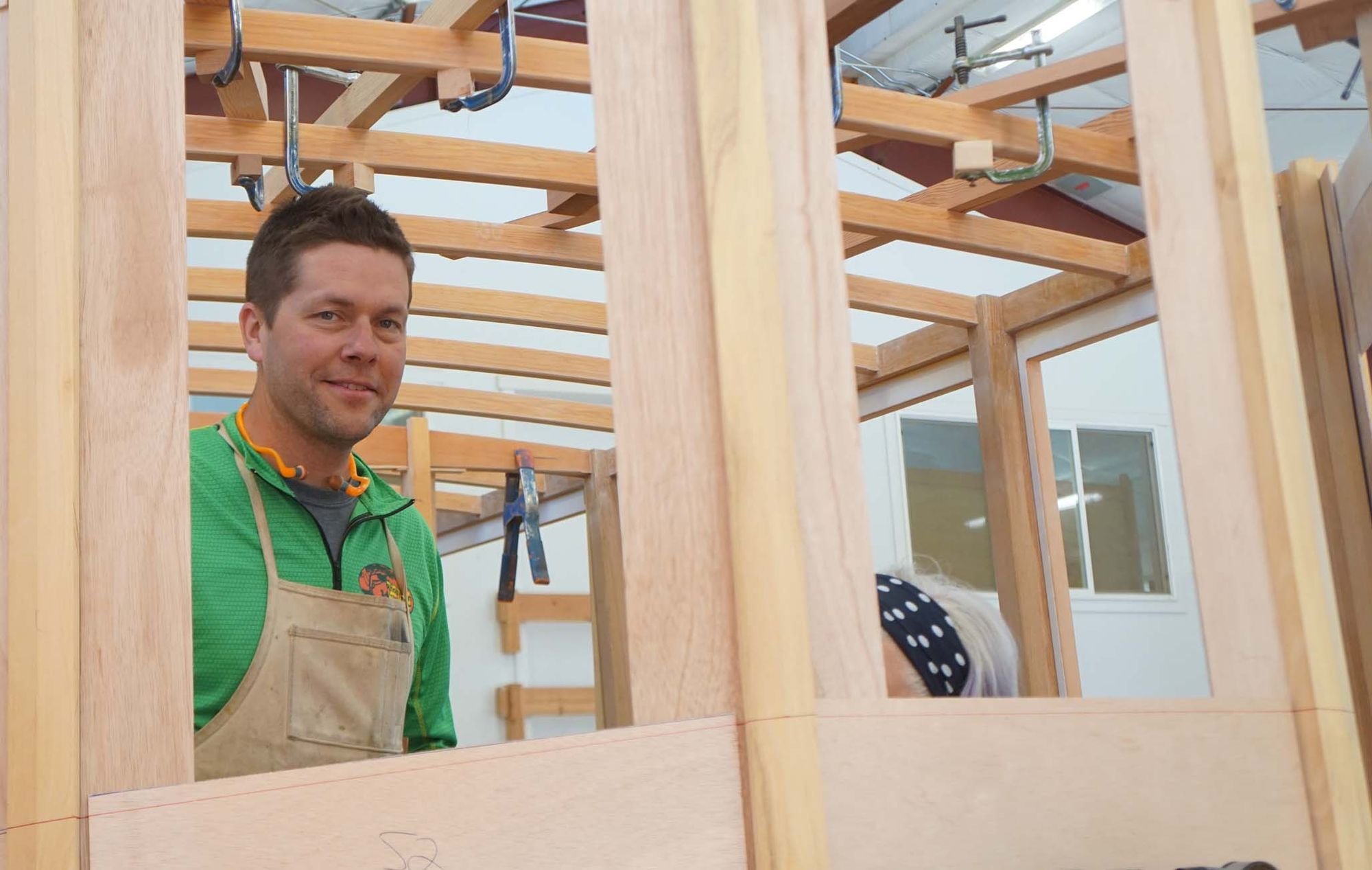  Sean Koomen, a former student of Vice Presidential Candidate Tim Walz,  stands within a boat under construction.   