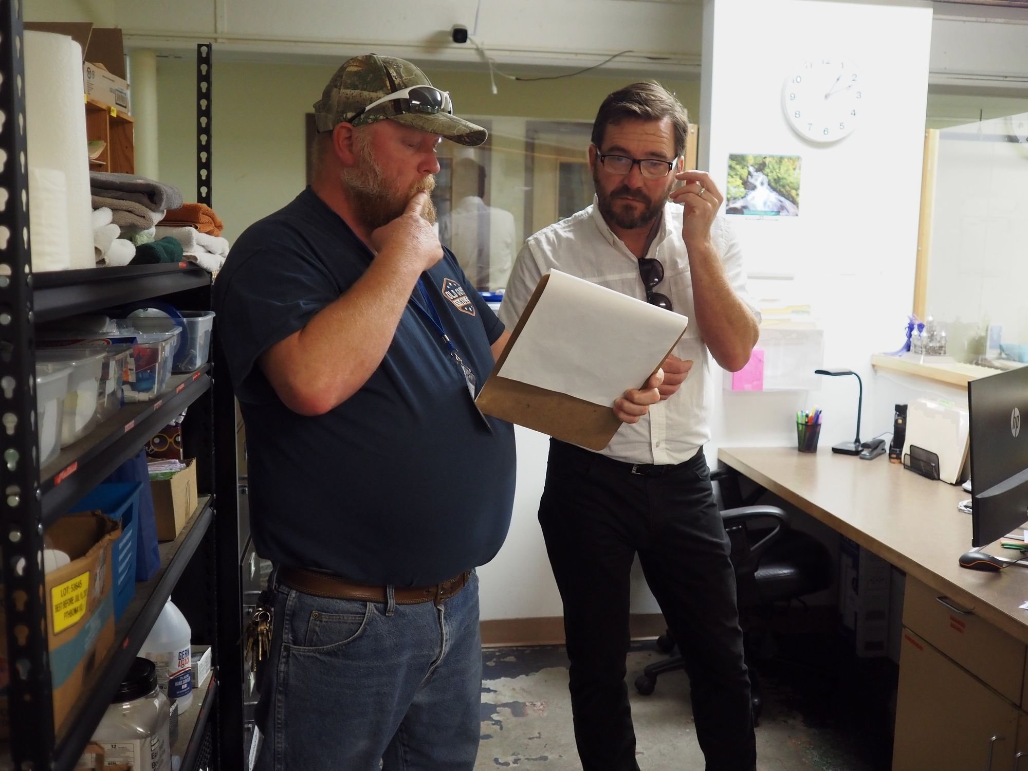   Shelter Manger Terry Strickland and County Commissioner Greg Brotherton discuss logs tracking offenses at the emergency shelter. Beacon photo by Derek Firenze  