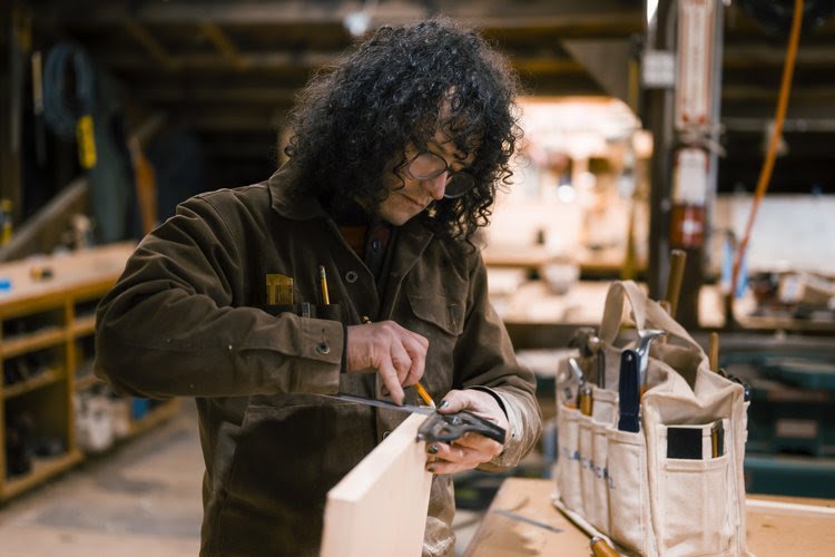   Haven Boatworks: Nic works on building a custom bookshelf. Photo by Heather Johnson.  