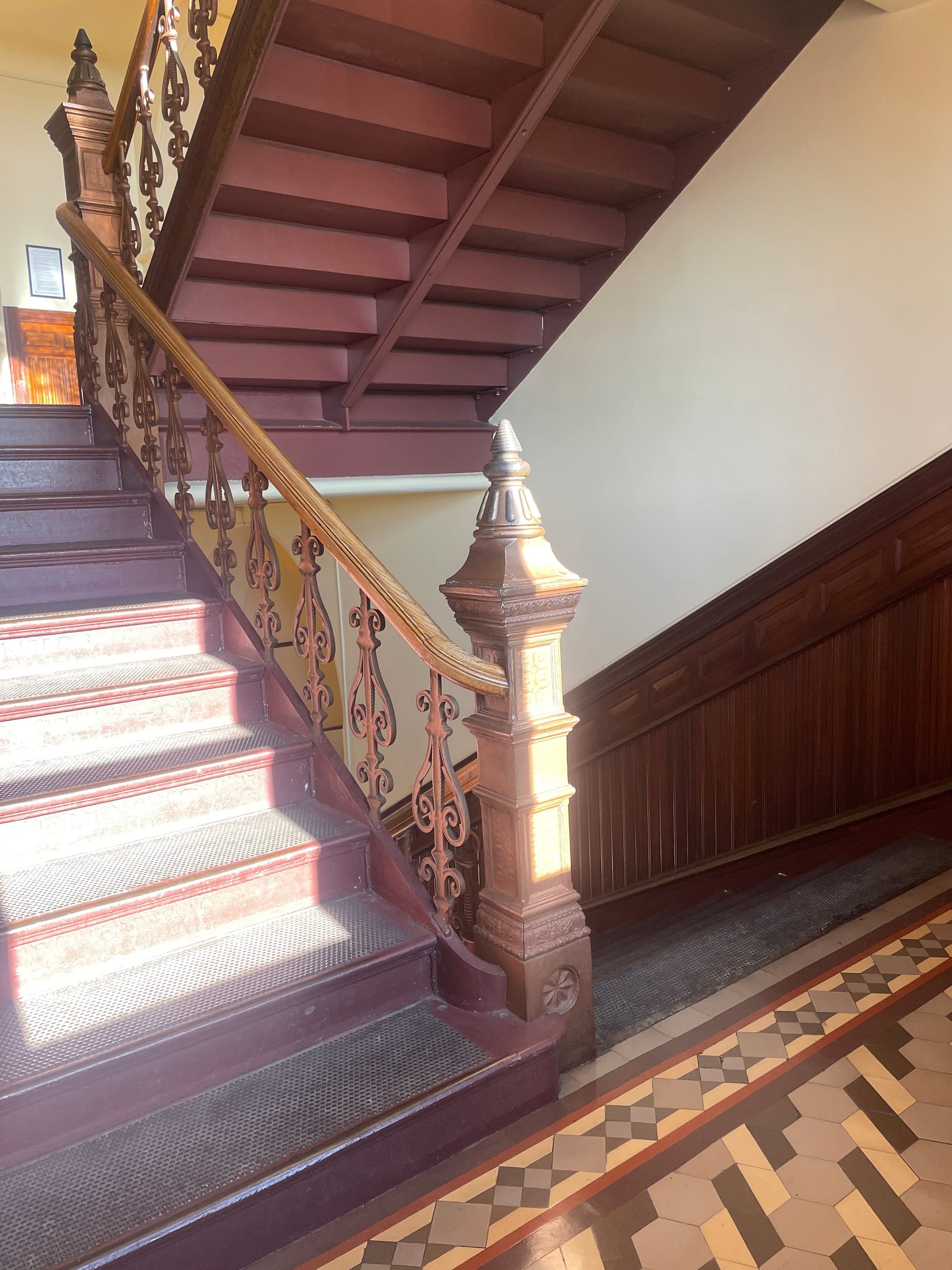 A brown and tan wood and tile stairwell 