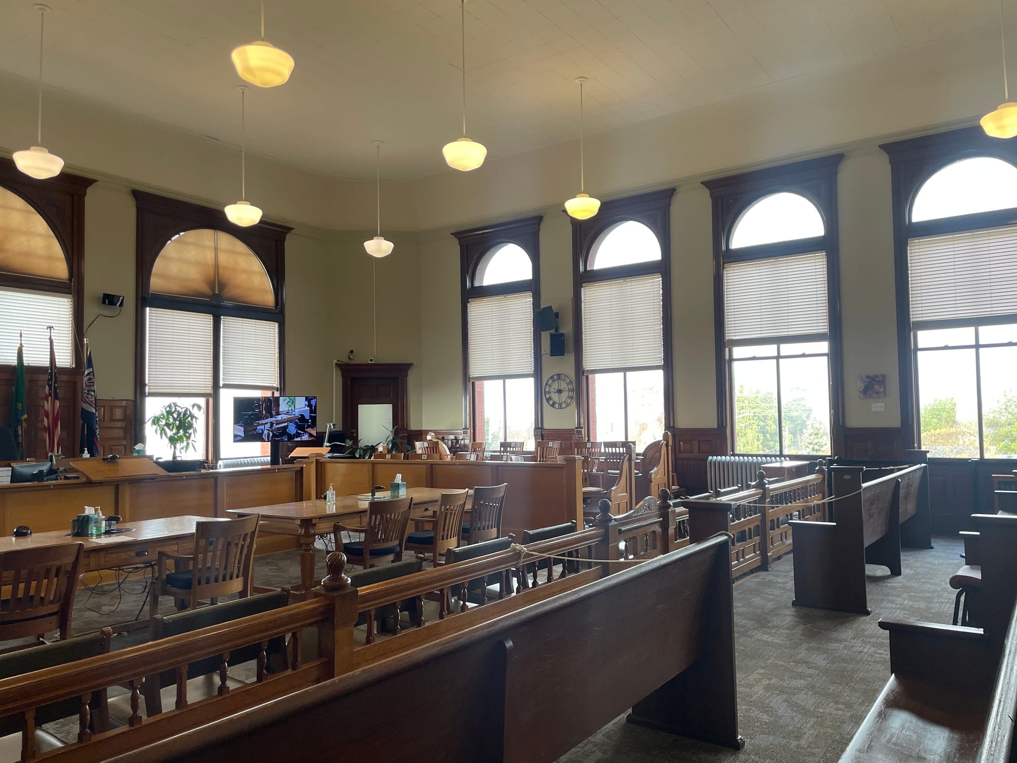 Jefferson County Superior Courtroom, view from the audience gallery. Large wooden benches facing the judge's bench. Large windows in the background.