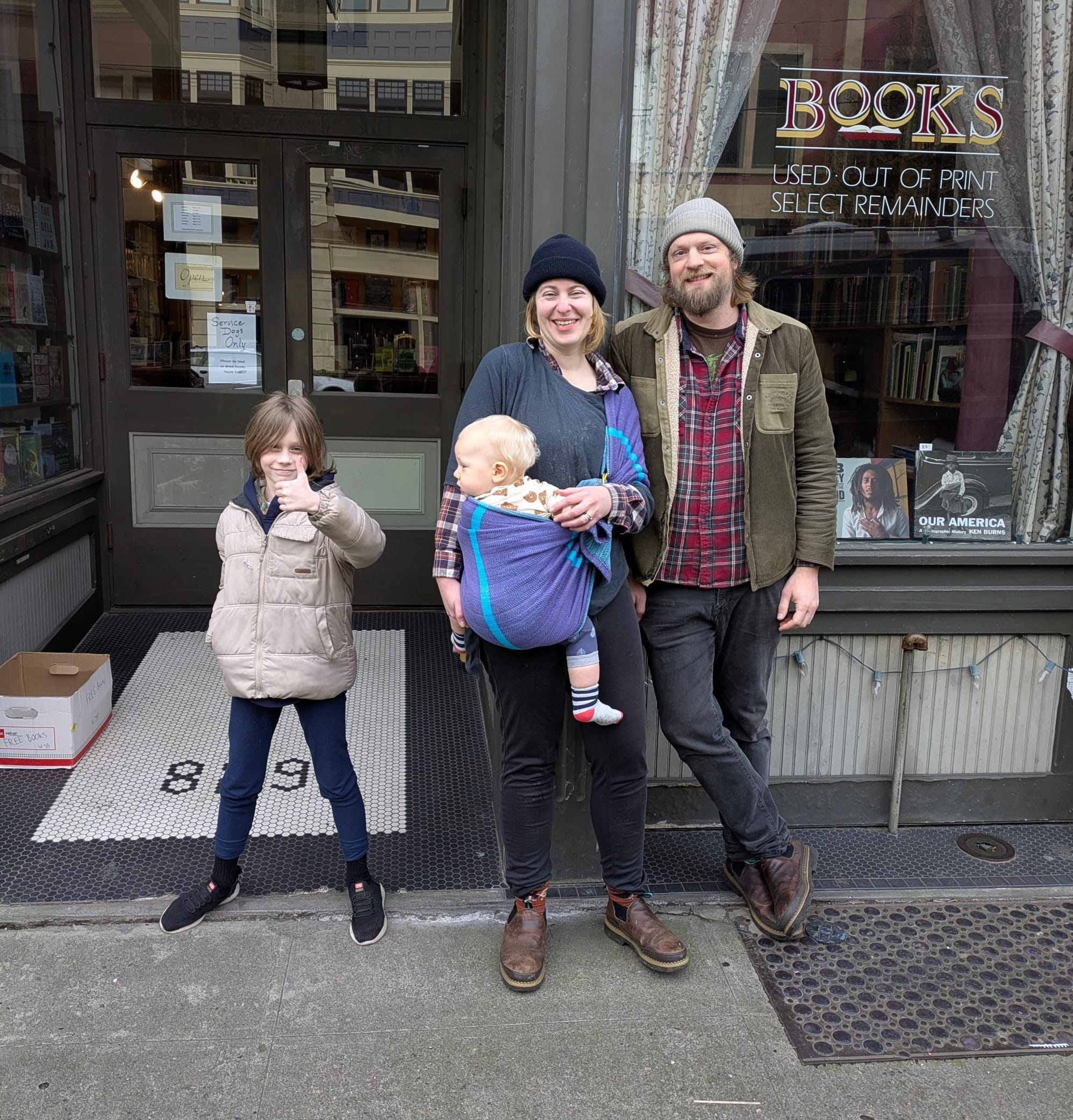 Eric Hatmaker and Rose Burt in front of William James Bookseller with their kids