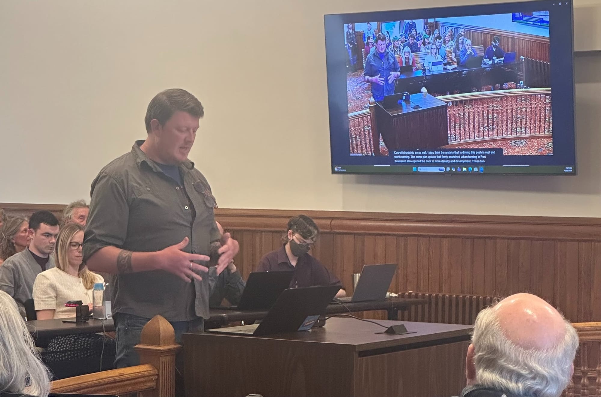 Dylan Quarles testifying in front of an audience with a laptop in front of him for notes.