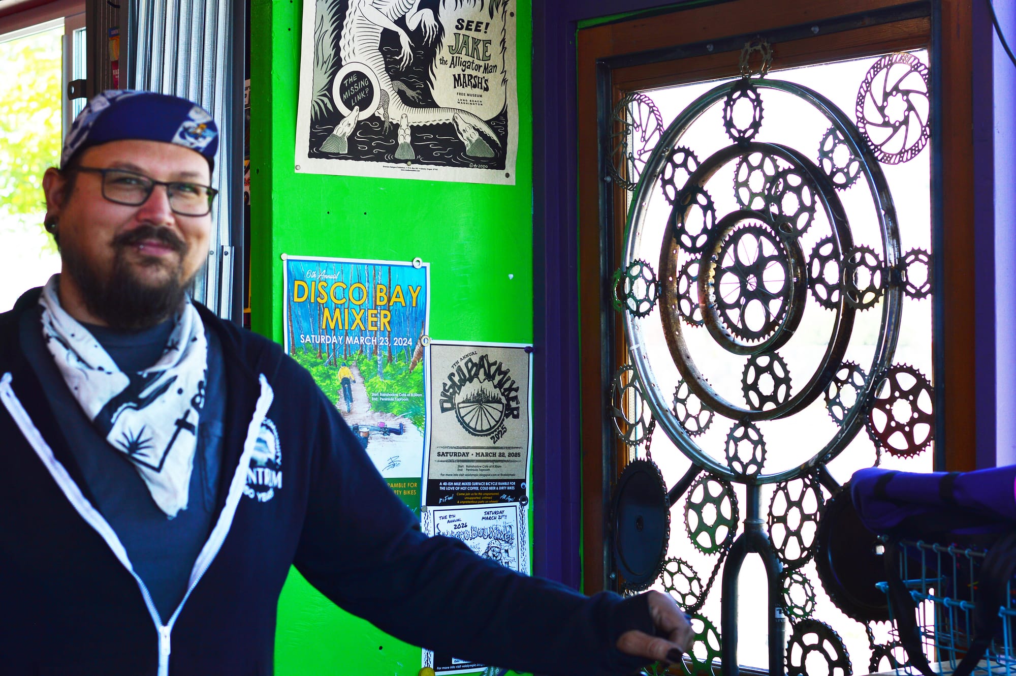  Gabe Quintanilla in front of one of his bike-part artworks made of bike gears.