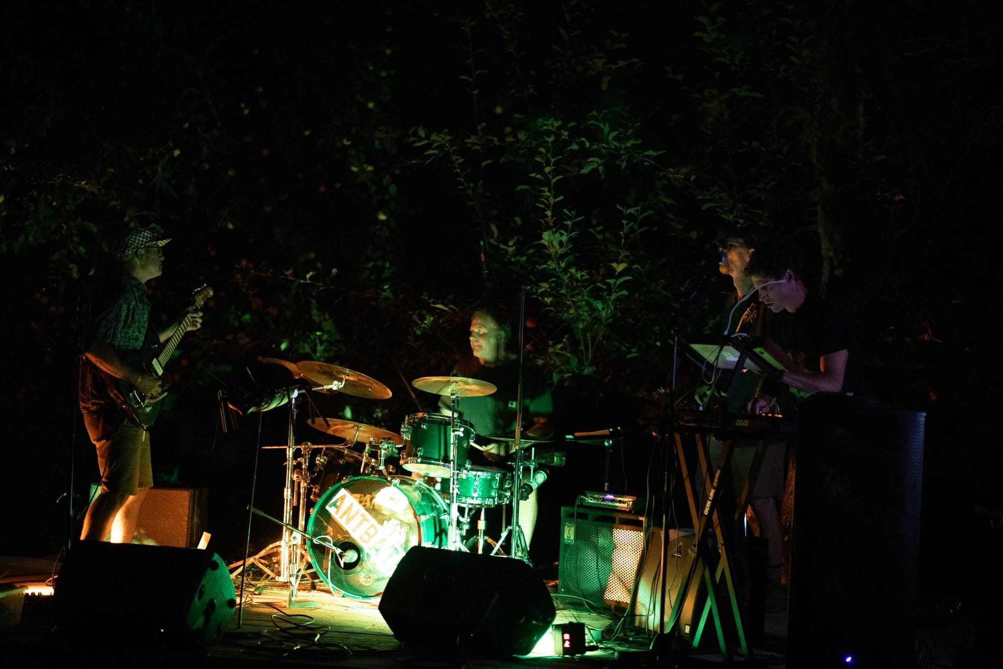 Band Antbath playing on an outdoor stage in the dark.
