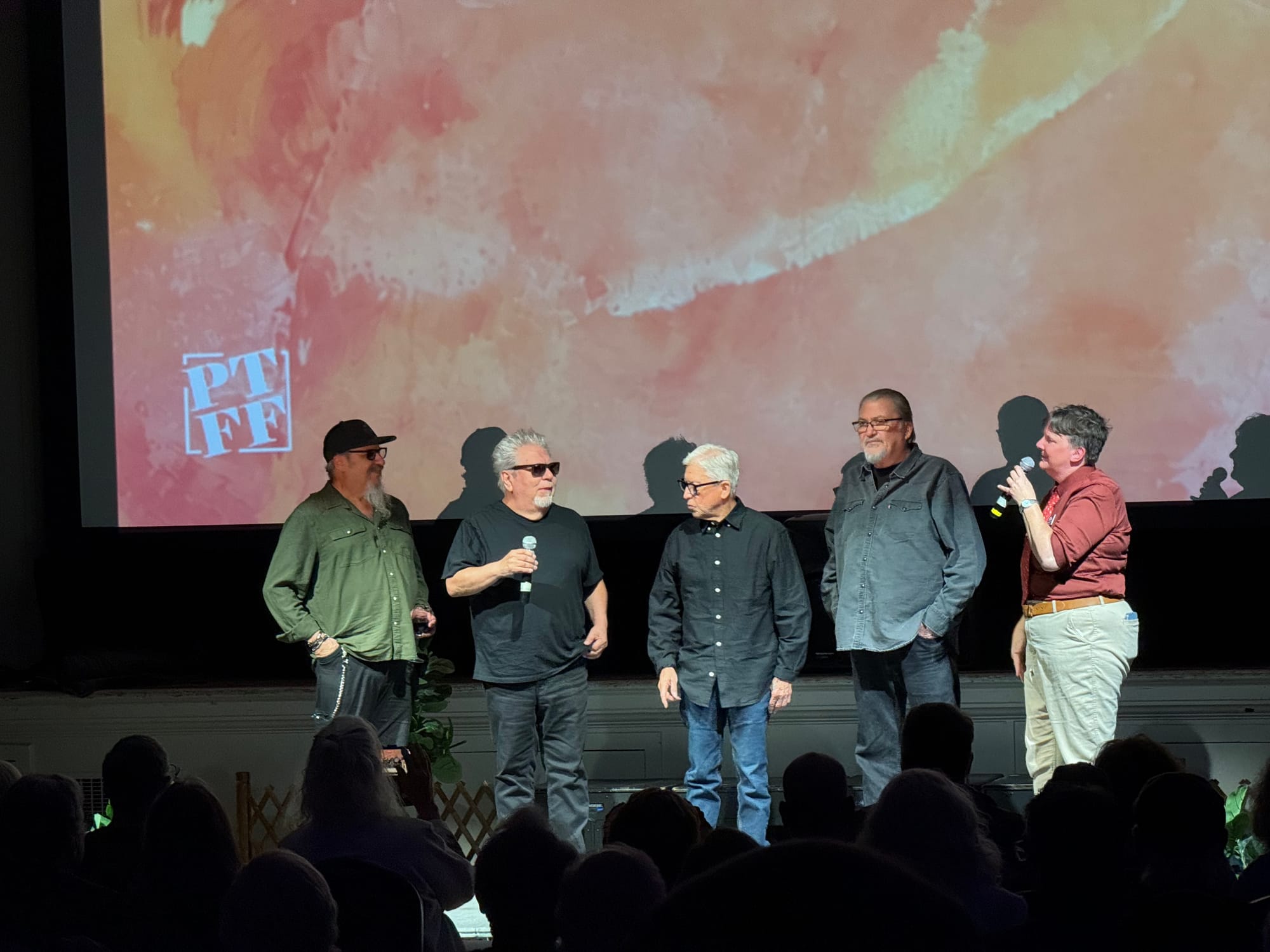 Los Lobos, including, from left, Steve Berlin, Cesar Rosas, Louie Pérez Jr. and David Hidalgo, are greeted by festival executive director Danielle McClelland at the American Legion on Sunday. 