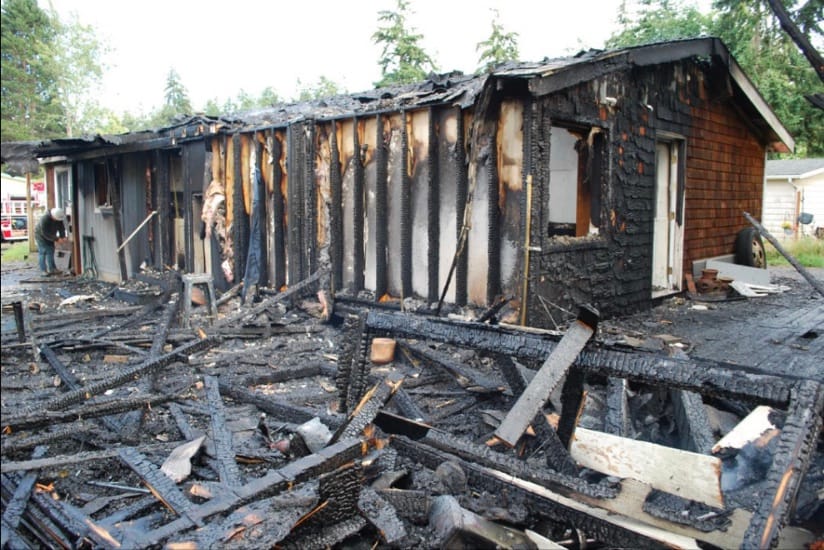 The charred remains of a burnt house and shed.