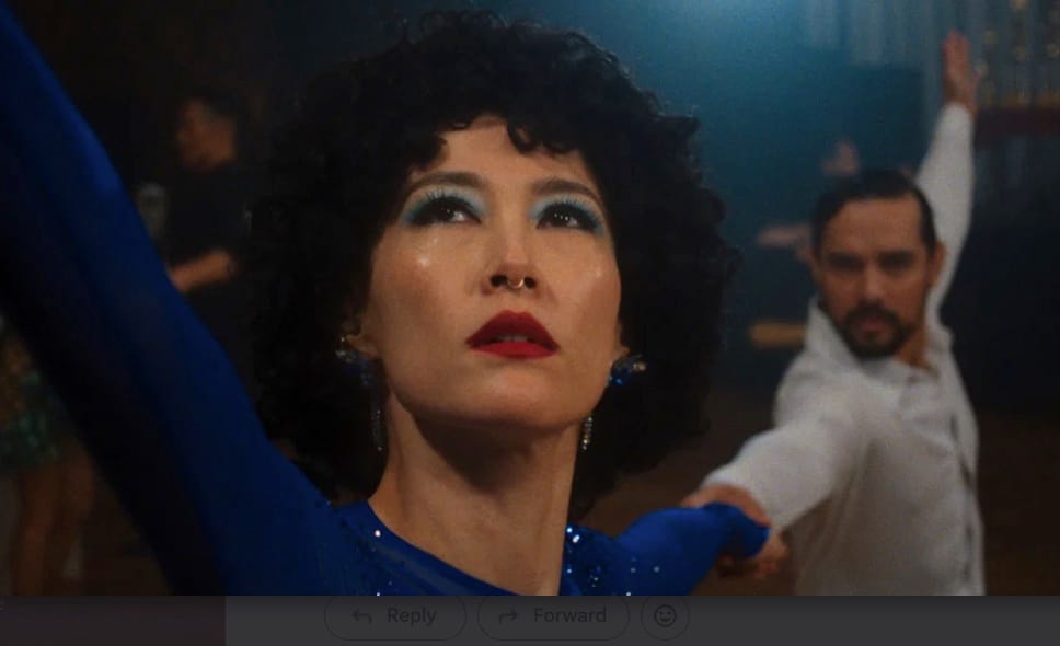 Haru (Rinko Kikuchi) in blue with dance partner in background.