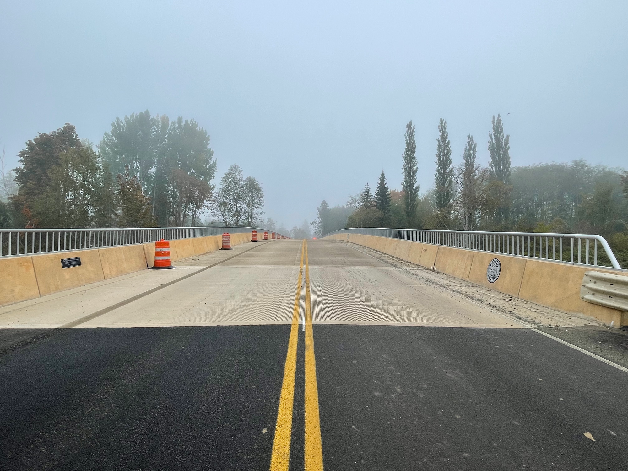 Looking from the center line across the Twana bridge, the pavement transitions from black top to tan cement. 